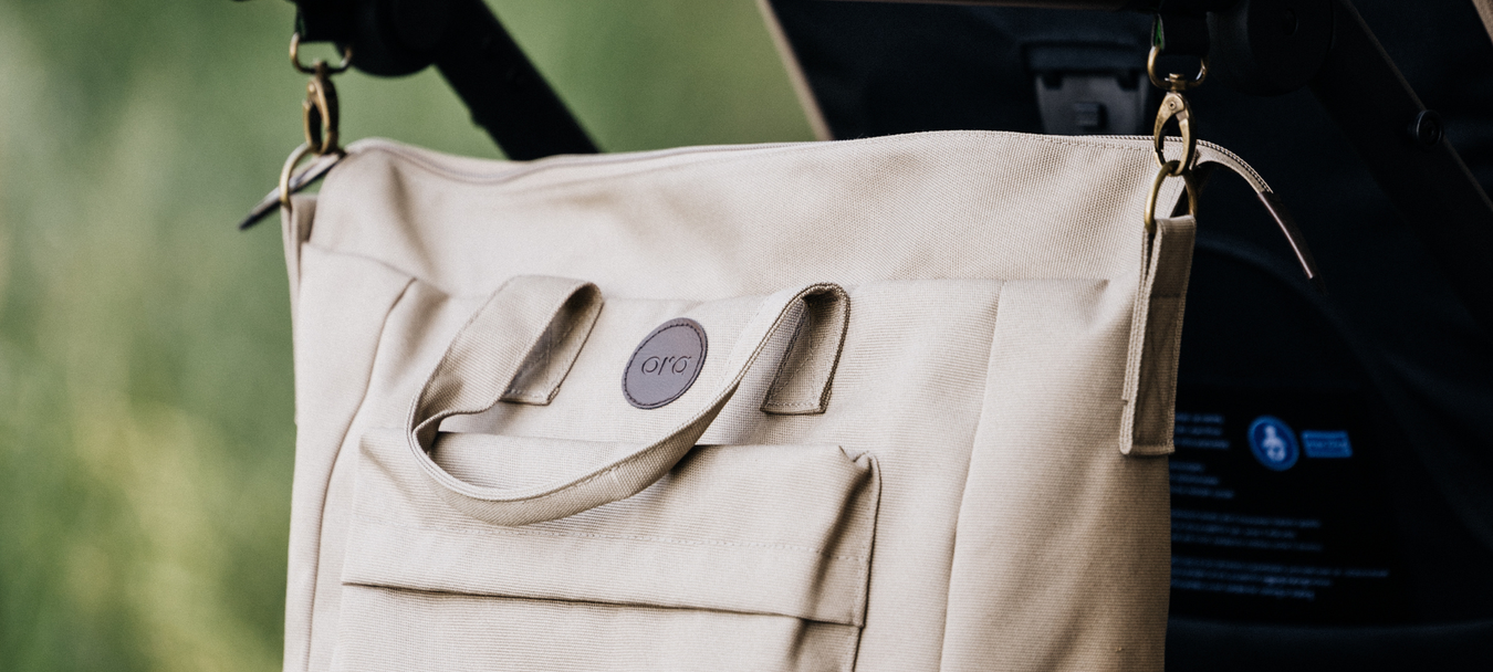 Oran hoitolaukku plus roikkumassa vaunujen työntöaisasta, beessi olki väri. 