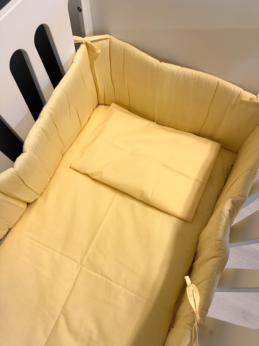 Vauvan keltainen pinnasängyn pussilakanasetti ja reunapehmuste