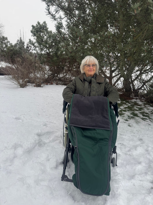 Nainen pyörätuolissa ja pyörätuolin lämpöpussissa