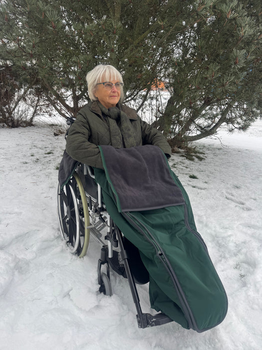Nainen pyörätuolin lämpöpussissa talvella