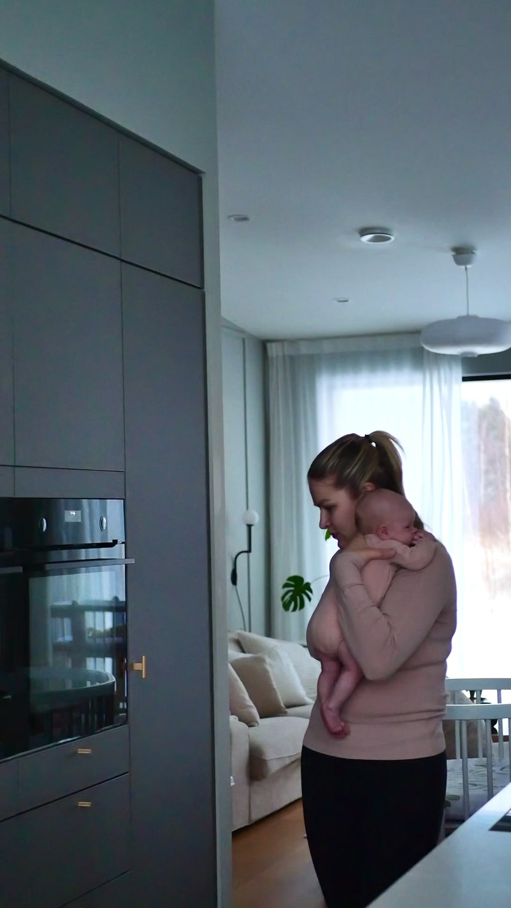 Ora Kielo video, äiti kuljettaa renkailla olevaa ensisänkyä ympäri keittiötä